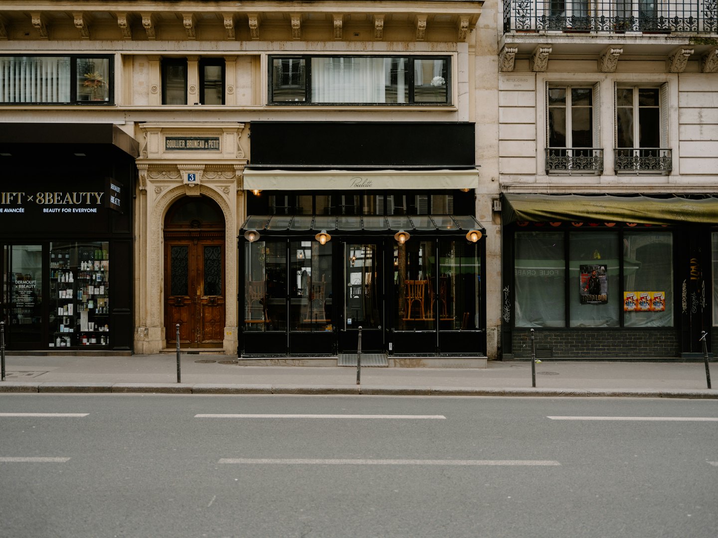 Europäische Straßenszene mit Schaufenstern und einem hölzernen Wohneingang.
